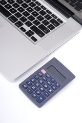 Laptop and calculator on table