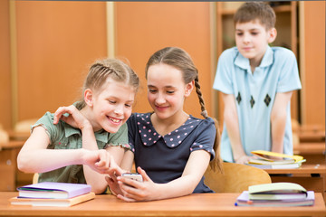 school kids with cell phones in classroom