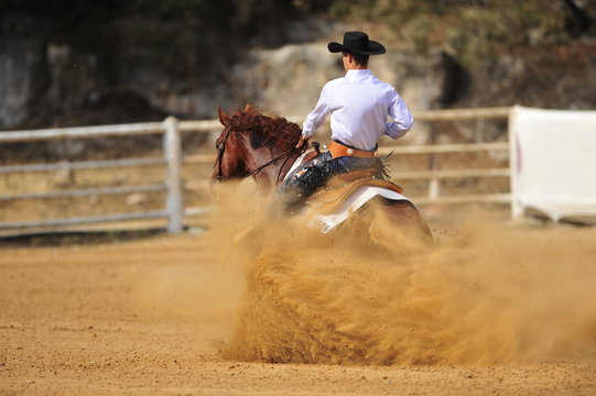 The rider is sliding a horse