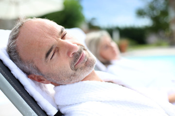 Senior man in spa hotel relaxing in long chair