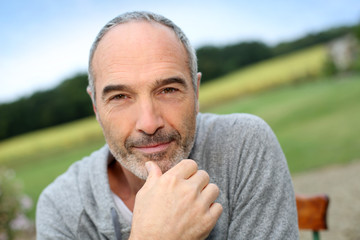 Cheerful casual senior man in countryside