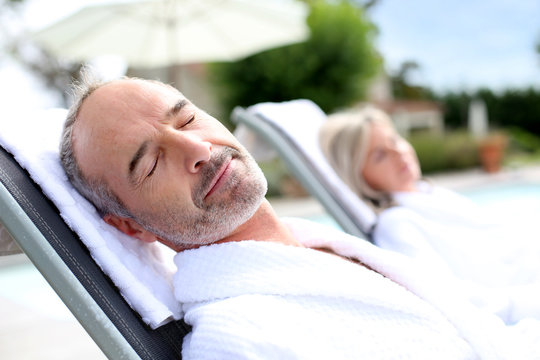 Senior Man In Spa Hotel Relaxing In Long Chair