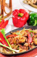 Spicy fried seafood on a hot pan.