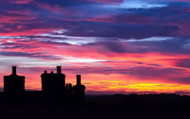 Fototapeta premium Beautiful sunset with house chimneys silouette