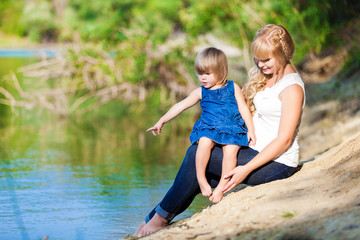 Fototapeta na wymiar happy young family spending time outdoor on a lake