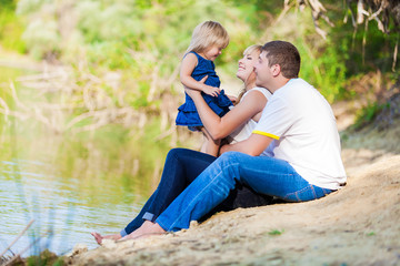 Fototapeta premium happy young family spending time outdoor on a lake