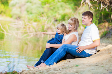 happy young family spending time outdoor on a lake
