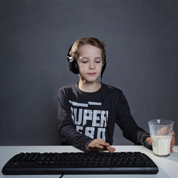enfant sur ordinateur avec verre de lait