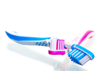 two toothbrushes crossed on a white background