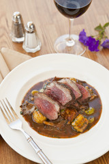 lamb sirloin with herbed gnocchi and glass of wine