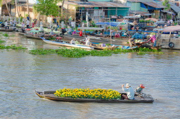 Fototapeta premium The man and colorful flowers boat at Nga Nam floating market, So