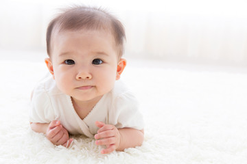 Fototapeta premium asian baby relaxing on the carpet