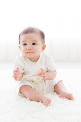 asian baby relaxing on the carpet