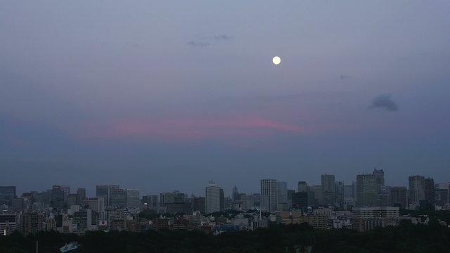 東京の高層ビル群と満月の夕方　インターバル撮影