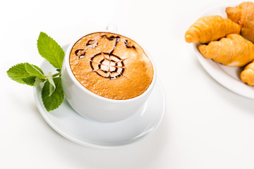 large cup of coffee and croissants on a plate