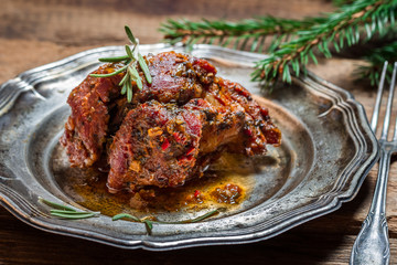 Metal plate of baked venison with rosemary