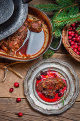 Roast venison with cranberry sauce and served in the forester lo