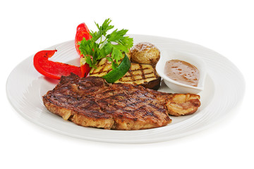 Grilled steaks, baked potatoes and vegetables on white plate.