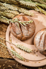 Grains and cereals on a wooden board with bread rolls