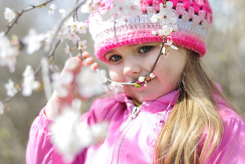 beautiful little girl near a flowering tree