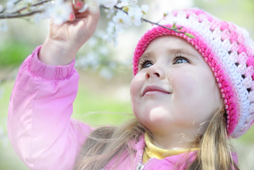 beautiful little girl near a flowering tree