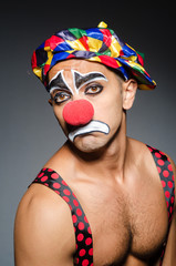 Sad clown against dark background