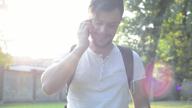 stylish young man on the phone at the park