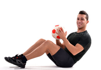 Jugador de fútbol sujetando un balón,entrenamiento.