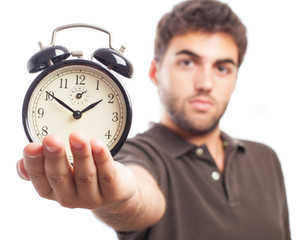 young man holding an alarm clock on a white background