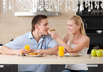 Married couple has breakfast in the modern comfortable kitchen