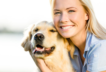 Close up of blond woman embracing golden retriever