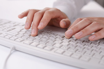 Male hands typing on a computer keyboard