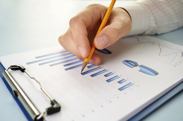Man holding a pencil working on a graph