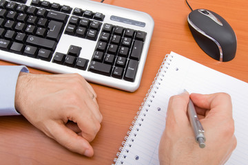 Business man writing in a notebook.