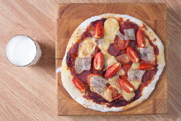 Closeup of homemade pizza with tomato, bacon, salami 