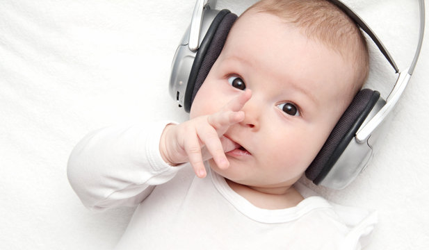 Baby Boy With Headphone Lies On Back