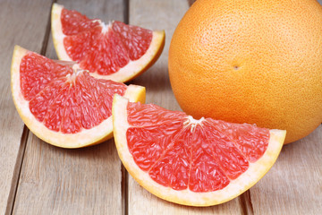 Sliced red grapefruit on a wooden background