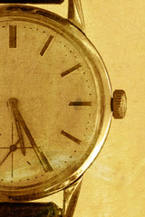 Old watch on a gold grunge background