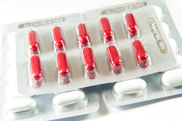 Red capsule in blister pack put on top white tablet