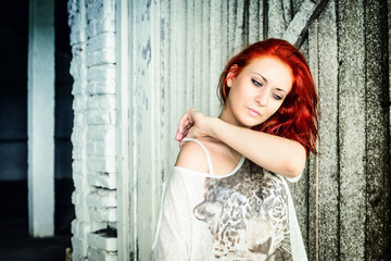 Fototapeta premium beautiful girl with red hair outdoor against wooden doors
