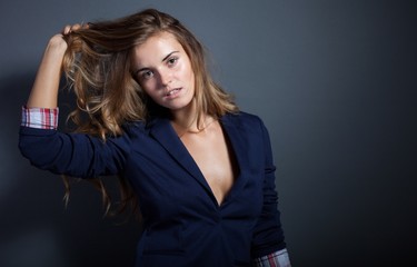 Sexy woman pulls hair, dark background