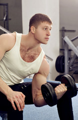 Fototapeta na wymiar Handsome young muscular sports man in gymnasium