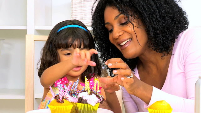 African American Mother Child Decorating Cupcakes Close Up