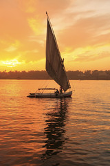 Bateau felouque naviguant sur le Nil au coucher du soleil, Louxor