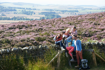 Group Of Young People Hiking Through Countryside