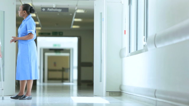 Older Patient Ethnic Nurse Hospital Corridor