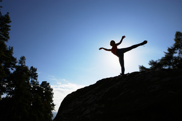 Silhouette Of Teenage Girl Balancing On Rock