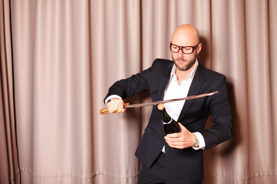 Mann k&ouml;pft Champagner mit Schwert