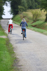 Senior couple riding bicycle in countryside
