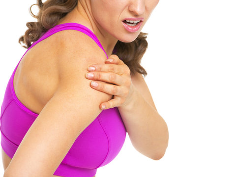 Closeup on fitness woman having pain in shoulder